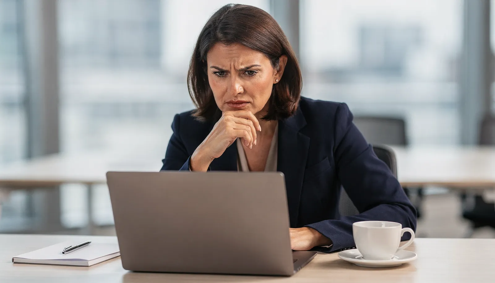 KI-Phishing erkennen: Buchhalterin liest täuschend echte Betrugsmail am Bildschirm