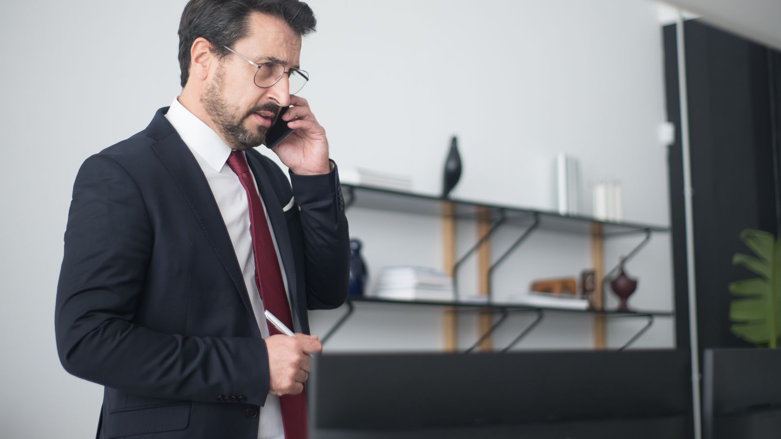 Kundenservice-Mitarbeiterin telefoniert konzentriert am Schreibtisch in einem modernen Büro