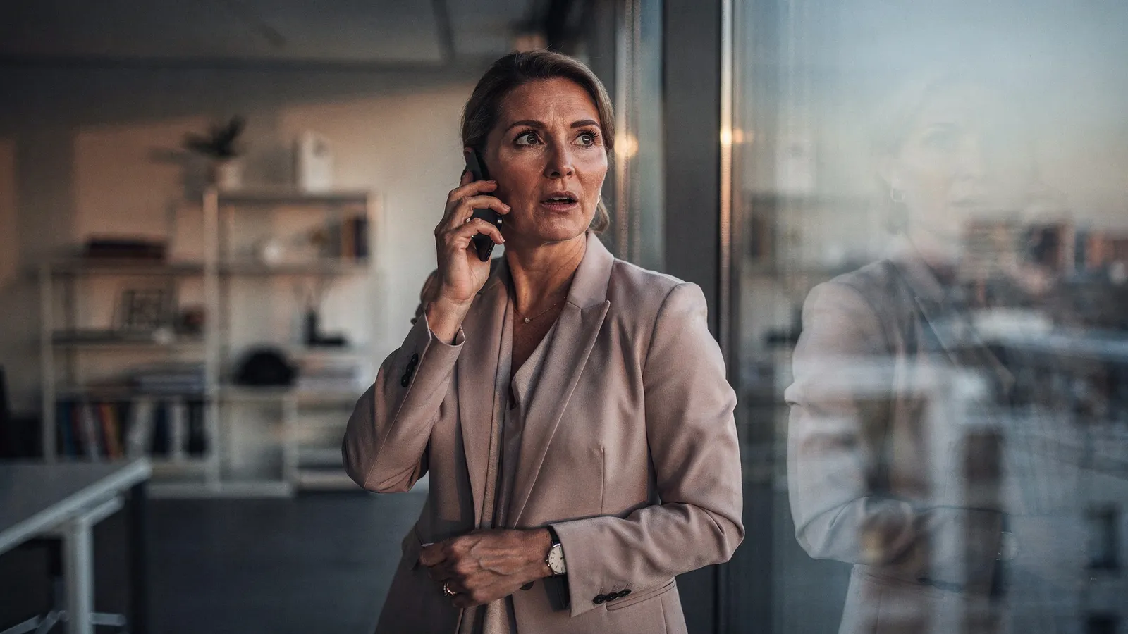 KI Stimme erkennen: Geschäftsfrau telefoniert abends im Büro und erkennt die KI-Stimme nicht